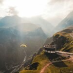 person paragliding on mountain cliff during daytime